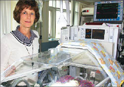 Ann Seaburg, of Deaconess' neonatal intensive care unit, displays one of 10 new "giraffe bed" isolettes being used there